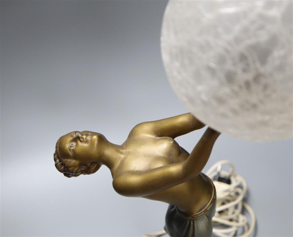 An Art Deco spelter table lamp, with female holding glass shade aloft, on stepped square base, 55cm
